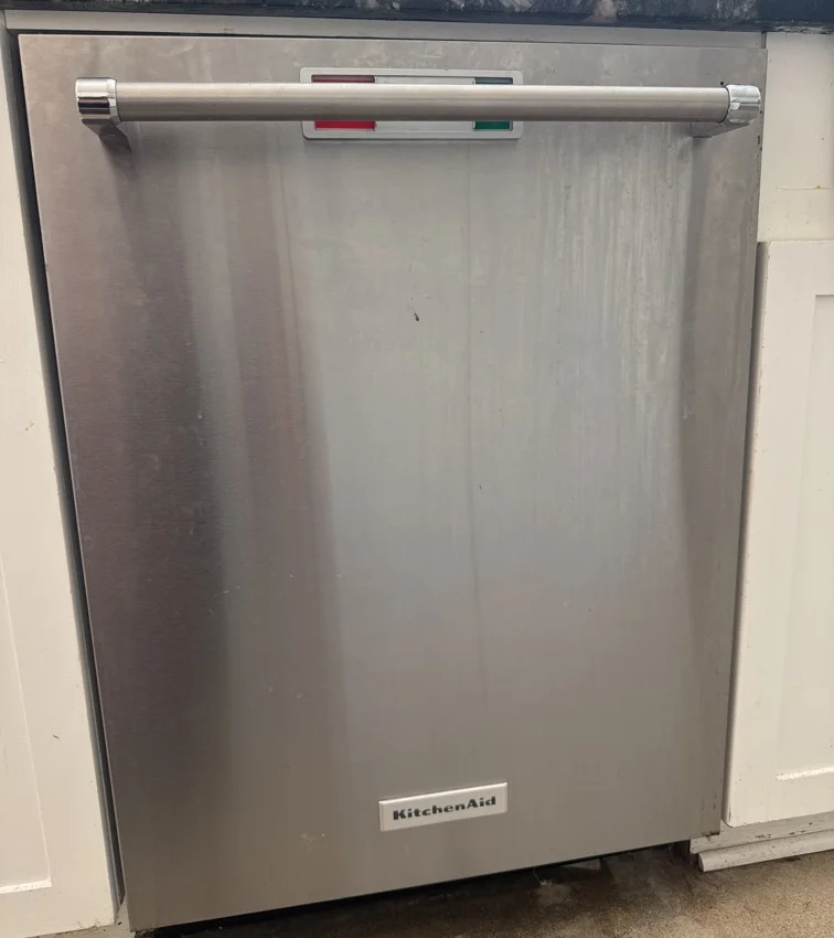 Stainless steel KitchenAid dishwasher installed beneath a kitchen counter