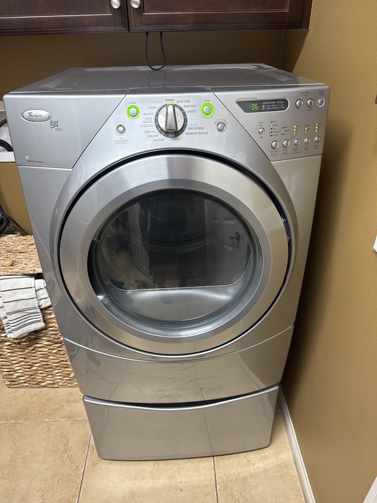 Silver front-load dryer in a home laundry room