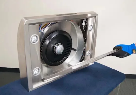 Range hood blower and wiring exposed on a workbench for service