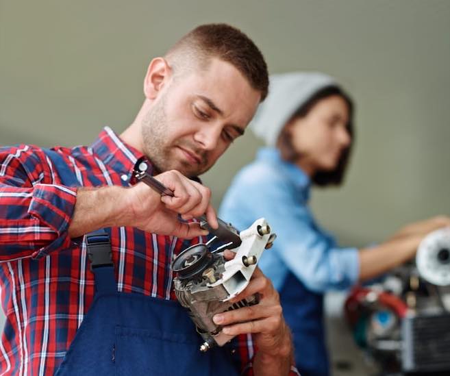 Technician examining an appliance component at a workbench